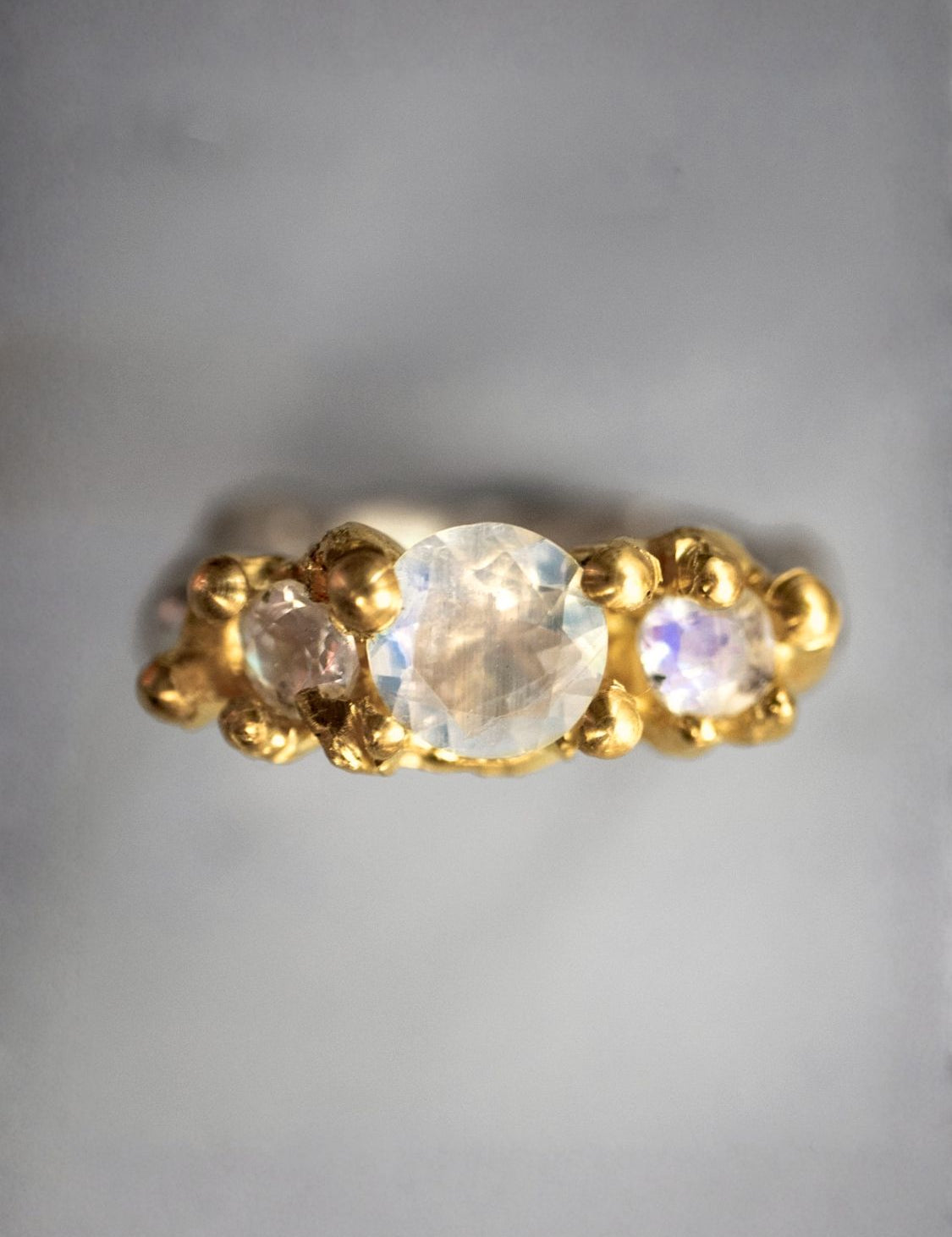 Gold ring with three moonstones on a gray background | The Bow Jewelry