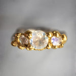 Gold ring with three moonstones on a gray background | The Bow Jewelry