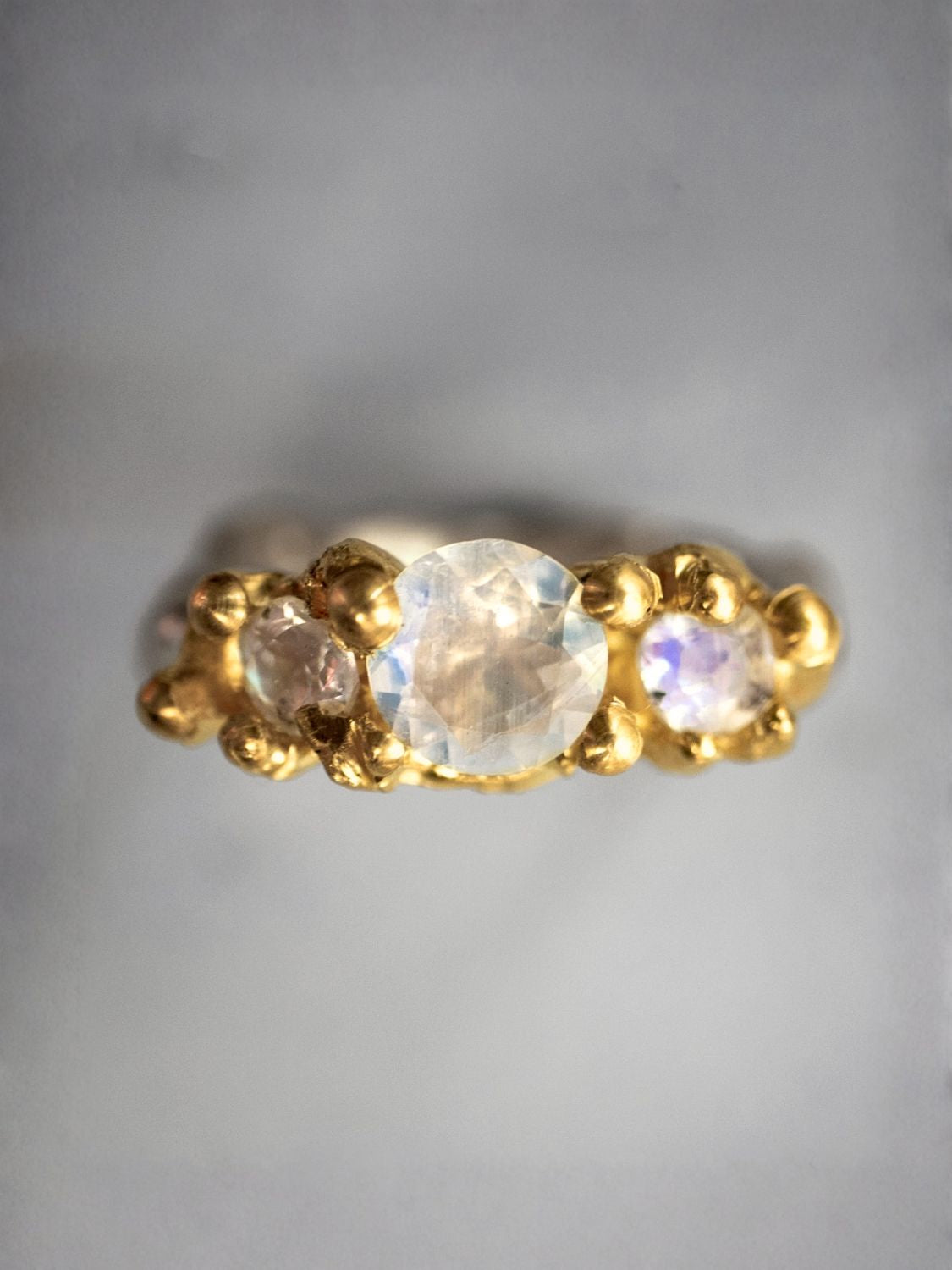 Gold ring with three moonstones on a gray background | The Bow Jewelry