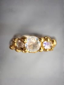 Gold ring with three moonstones on a gray background | The Bow Jewelry