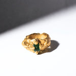 Gold ring with a emerald gemstone on a white background - The Bow Jewelry