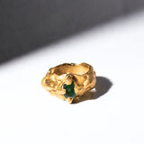Gold ring with a emerald gemstone on a white background - The Bow Jewelry