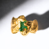 Gold ring with a emerald gemstone on a white background - The Bow Jewelry
