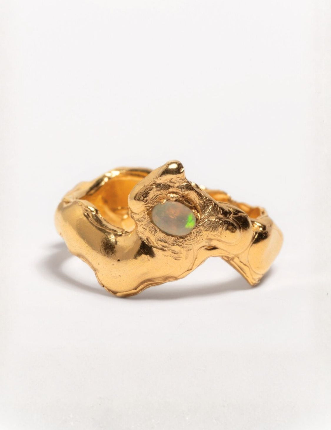 A gold-plated band ring with a faceted natural fire opal gemstone set in the center, displayed on a plain background | The Bow Jewelry