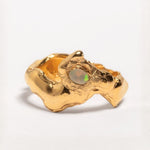 A gold-plated band ring with a faceted natural fire opal gemstone set in the center, displayed on a plain background | The Bow Jewelry