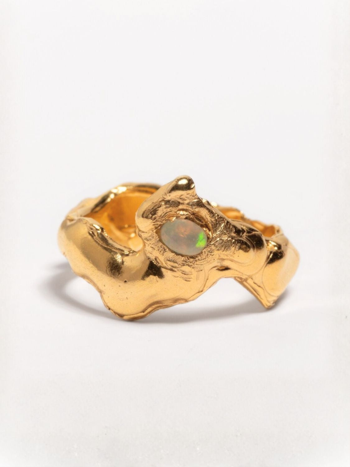 A gold-plated band ring with a faceted natural fire opal gemstone set in the center, displayed on a plain background | The Bow Jewelry