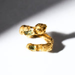 Gold snake shaped ring with two emerald gemstones on a white background - The Bow Jewelry