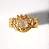 Gold ring with a central gemstone on an eye shape and white background
