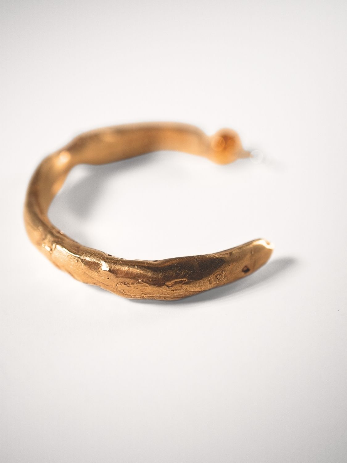 Gold goddess hoop on a white background