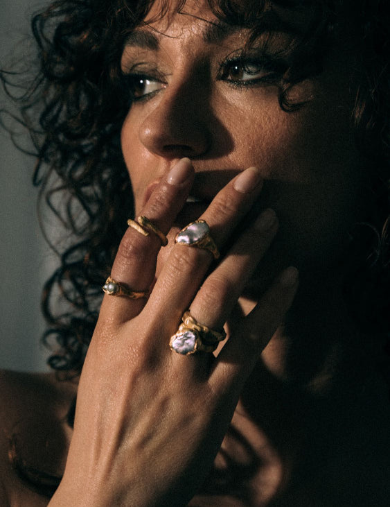 Model wearing multiple versions of Mercury Gold Plated ring with a pearl and Shadow Serpent ring | The Bow Jewelry