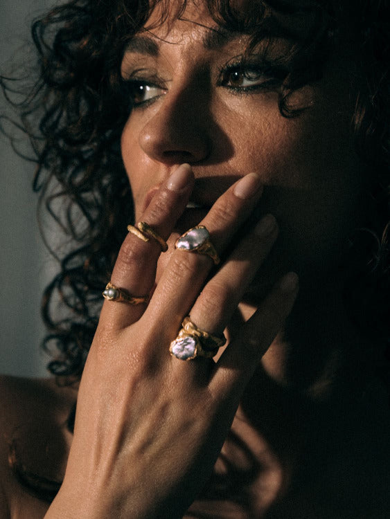 Model wearing multiple versions of Mercury Gold Plated ring with a pearl and Shadow Serpent ring | The Bow Jewelry