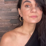 Woman wearing gold Sculptural Goddess hoop earrings | The Bow Jewelry