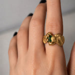 Gold ring with a emerald gemstone on a hand - The Bow Jewelry
