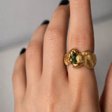 Gold ring with a emerald gemstone on a hand - The Bow Jewelry