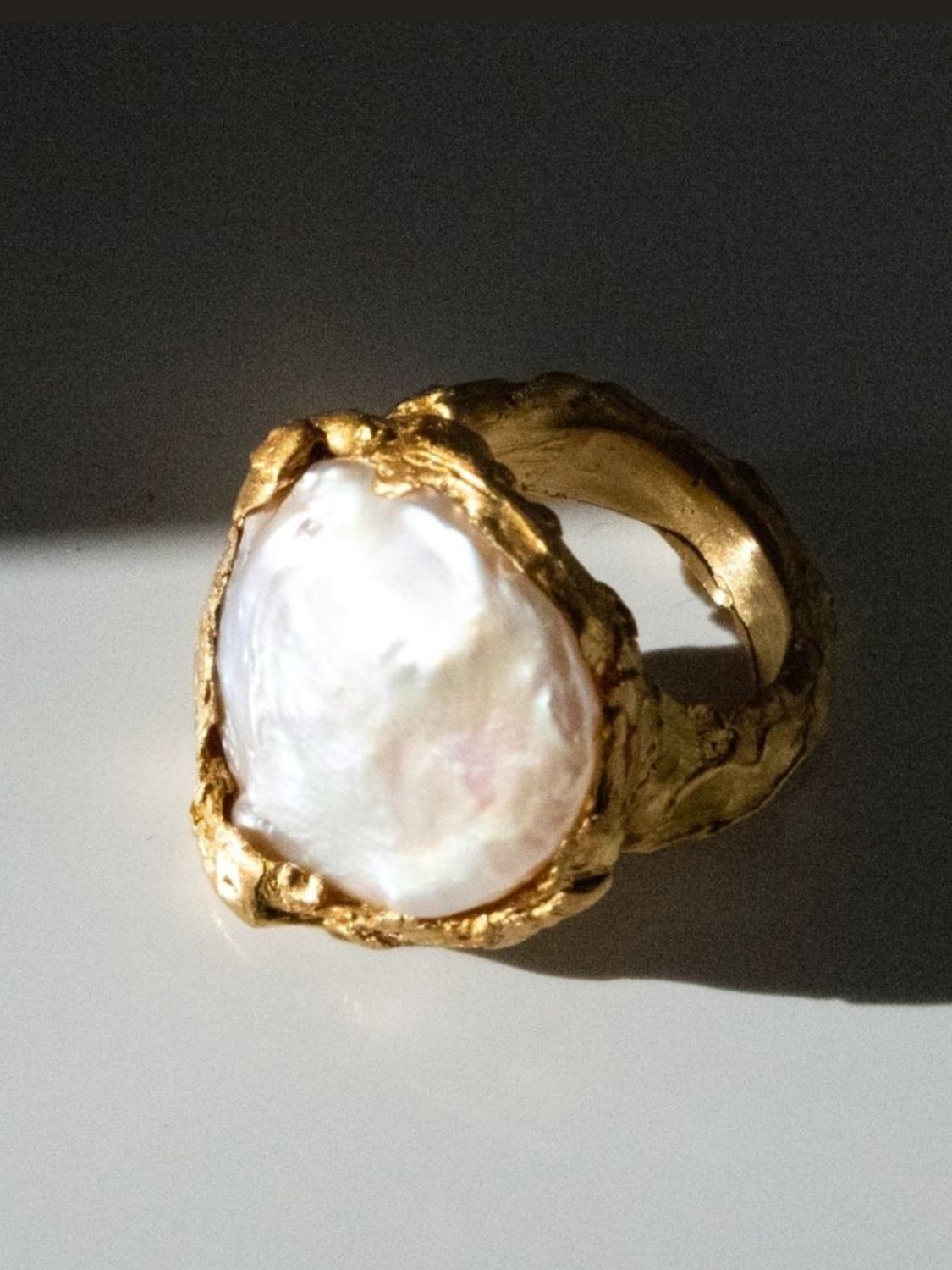 Gold ring with a large pearl on a dark background | The Bow Jewelry