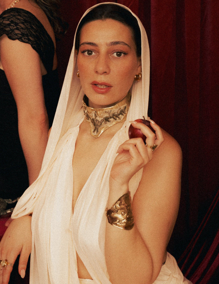 Woman in a white saree with Warriors Weave necklace against a dark background - The Bow Jewelry