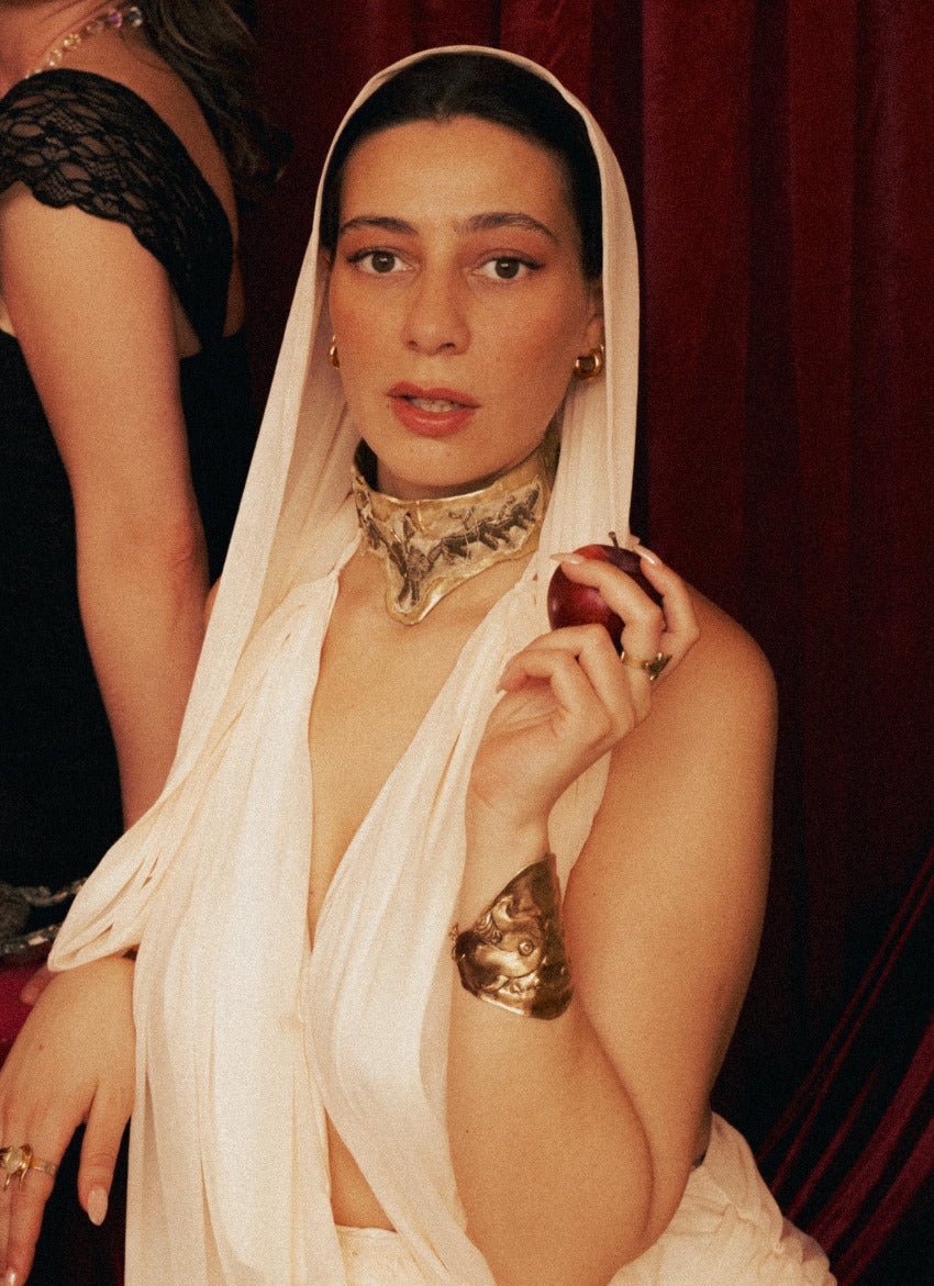 Woman in a white saree with Warriors Weave necklace against a dark background - The Bow Jewelry
