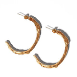 Gold goddess hoops on a light grey background | The Bow Jewelry