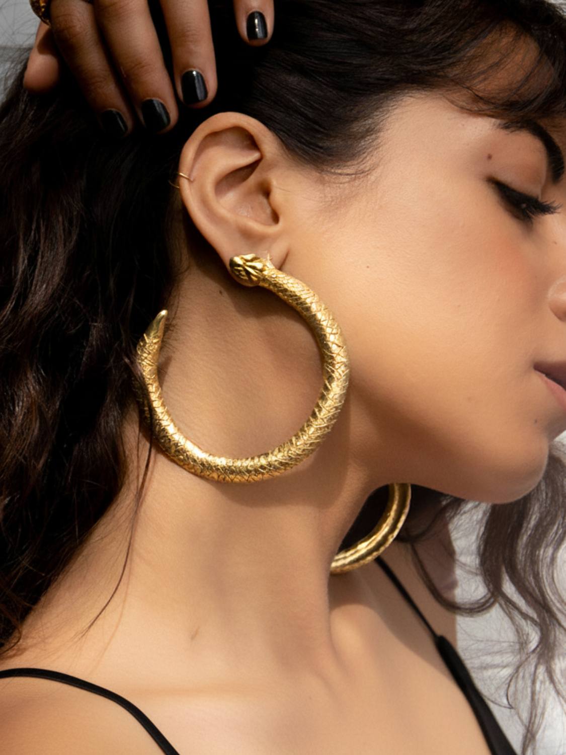 Gold Serpent Ouroboros hoop earrings on a white marble surface | The Bow Jewelry