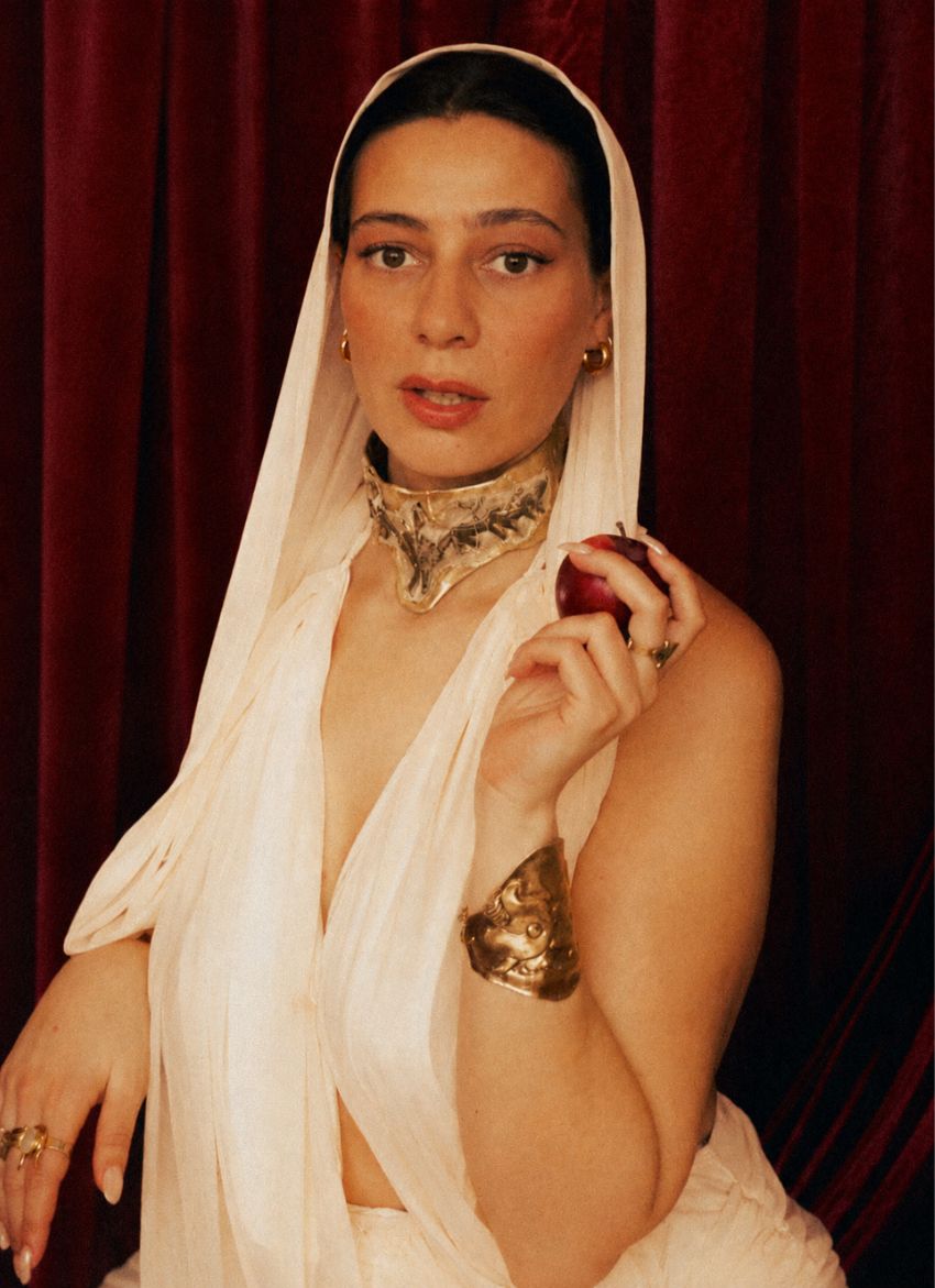 Woman in a white saree with Warriors Weave necklace against a dark background - The Bow Jewelry