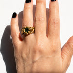 Gold ring with a emerald gemstone on a hand - The Bow Jewelry