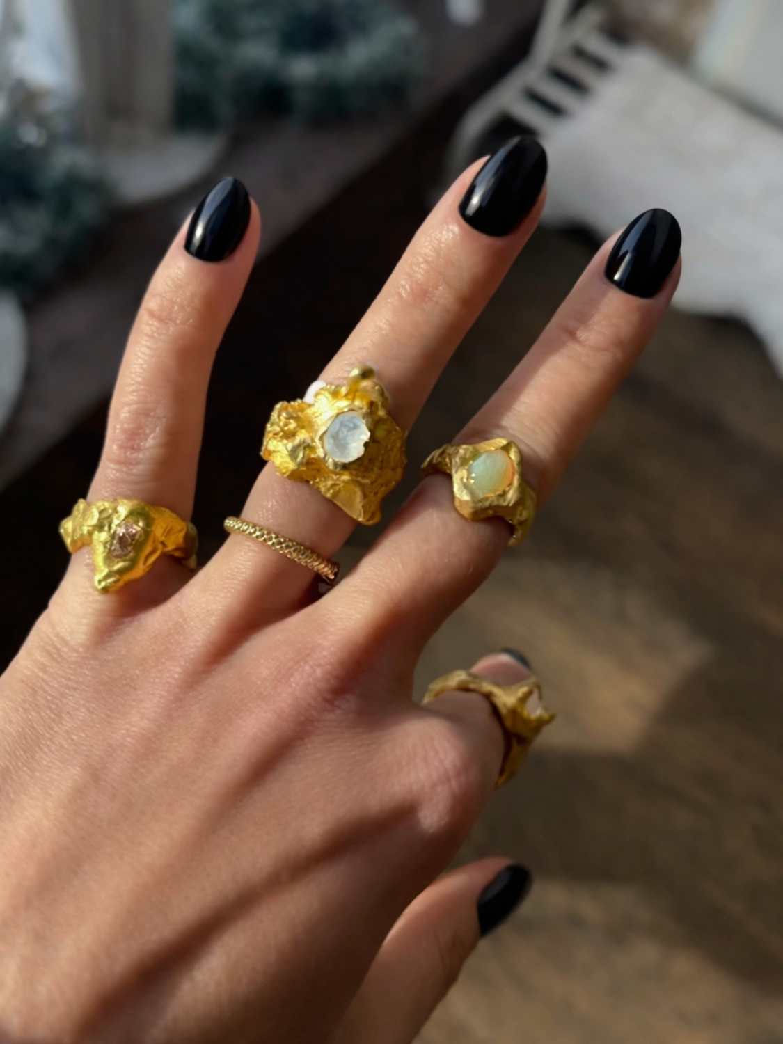 Close-up of a hand wearing a Nyx ring set with a moonstone |The Bow Jewelry