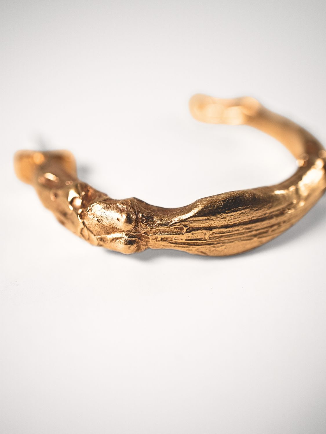 Gold goddess hoops on a light grey background