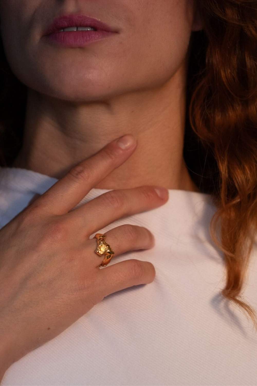 Model wearing gold-plated sculptural ring with a faceted natural fire opal gemstone set in the center | The Bow Jewelry
