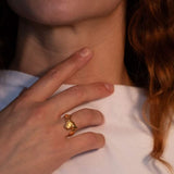 Model wearing gold-plated sculptural ring with a faceted natural fire opal gemstone set in the center | The Bow Jewelry