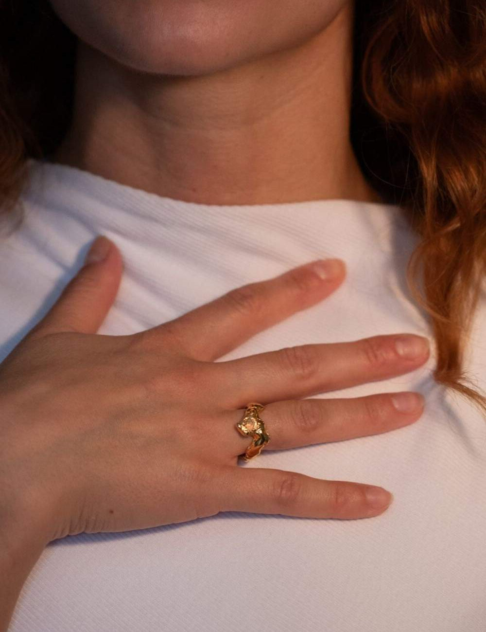 Model wearing gold-plated sculptural ring with a faceted natural fire opal gemstone set in the center | The Bow Jewelry