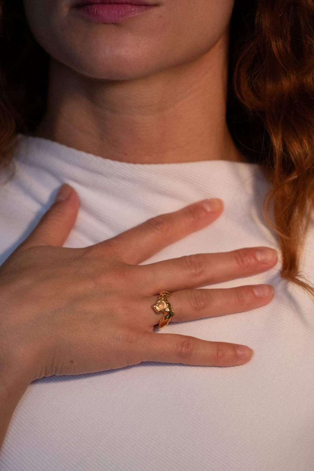 Model wearing gold-plated sculptural ring with a faceted natural fire opal gemstone set in the center | The Bow Jewelry
