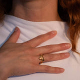 Model wearing gold-plated sculptural ring with a faceted natural fire opal gemstone set in the center | The Bow Jewelry