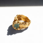 Gold ring with a emerald gemstone on a white background - The Bow Jewelry