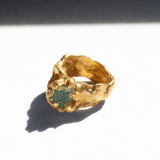Gold ring with a emerald gemstone on a white background - The Bow Jewelry
